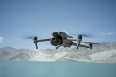 DJI Air 3S drone flying over frozen lake and snowy mountains