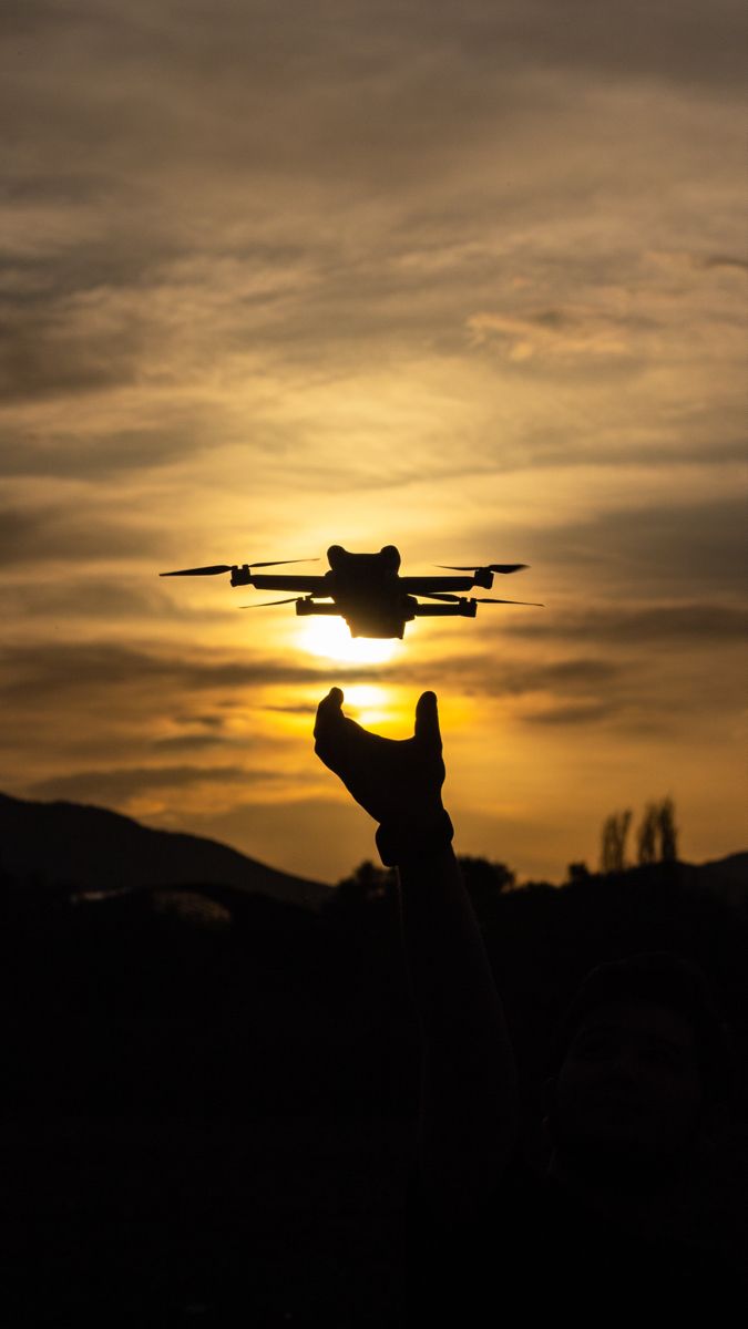 DJI Air 3S drone flying during dramatic sunset background