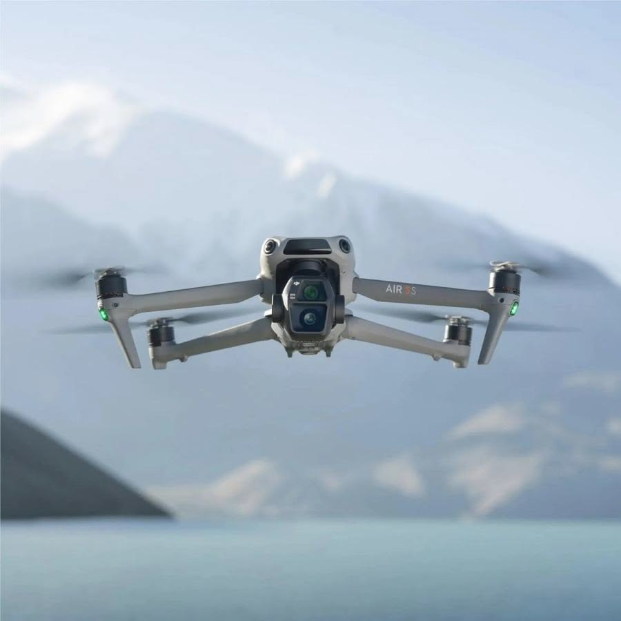DJI Air 3S drone hovering over cloudy mountain landscape