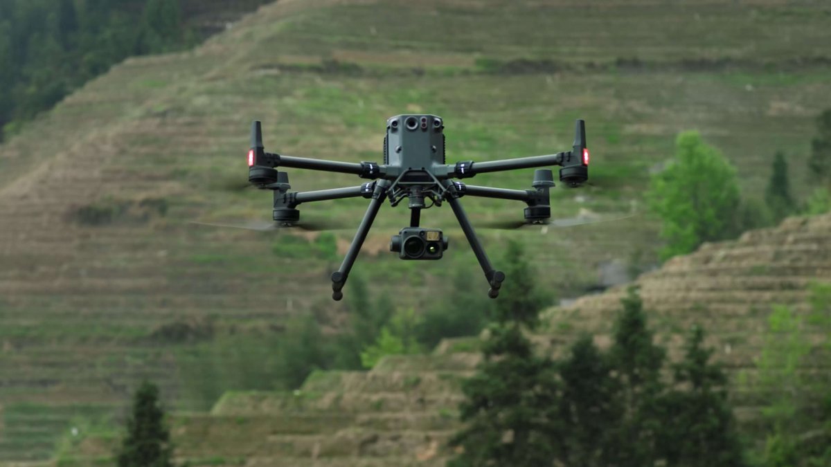 DJI Matrice enterprise drone hovering over green hills